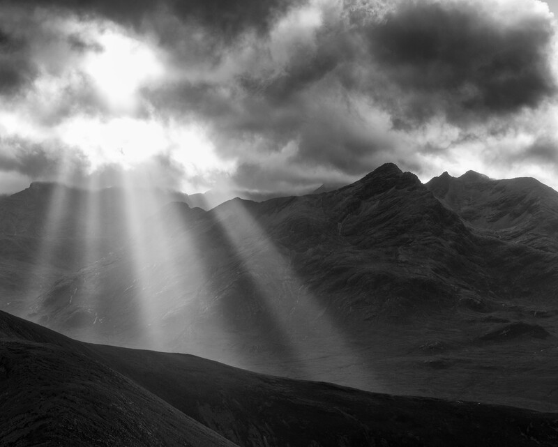 Sun bursts through the clouds over the Black Cuillin