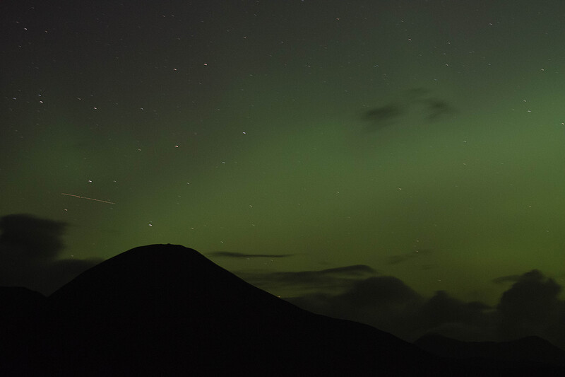 The green glow of the northern lights behind Beinn na Caillich